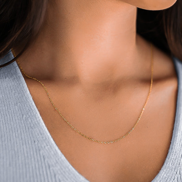 Woman wearing a 1.5mm gold cable chain necklace on her neck