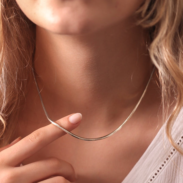 Woman wearing a 2.5mm silver snake chain necklace