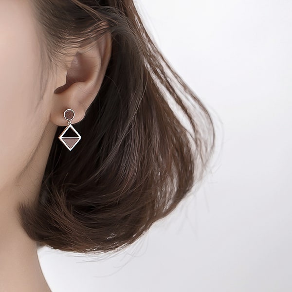 Woman wearing asymmetrical geomteric drop dangle earrings