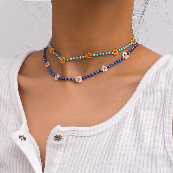 Woman wearing a blue beaded daisy flower choker necklace