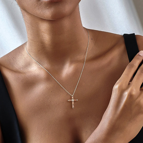 Woman wearing a cognac crystal cross on a silver necklace