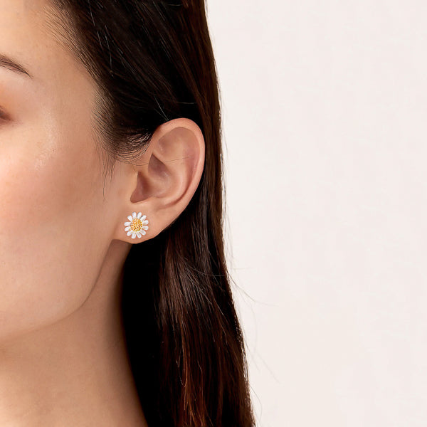 Woman wearing daisy stud earrings