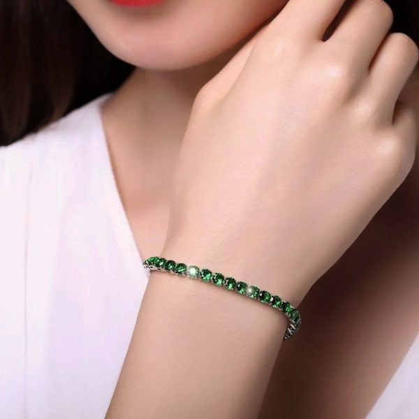 Emerald green cubic zirconia tennis bracelet on a woman's wrist