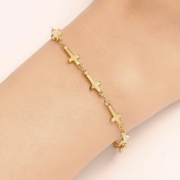 Woman wearing a gold cross chain bracelet