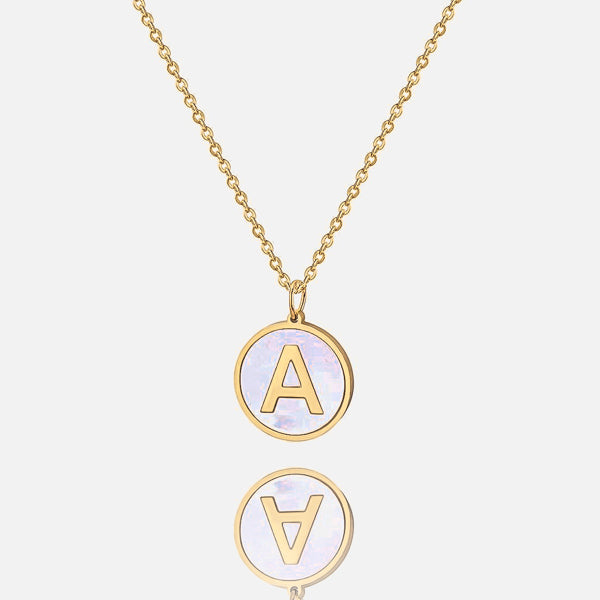 Gold and pearly white round letter coin pendant necklace closeup