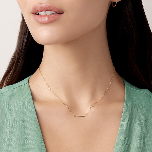 Woman wearing a gold bar necklace