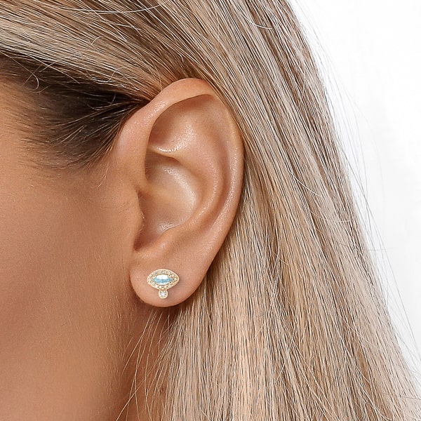 Woman wearing gold blue crystal eye stud earrings