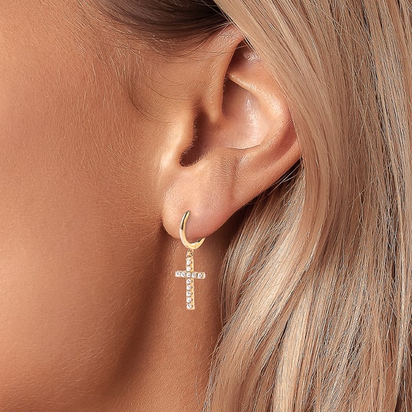 Woman wearing gold cross hoop earrings