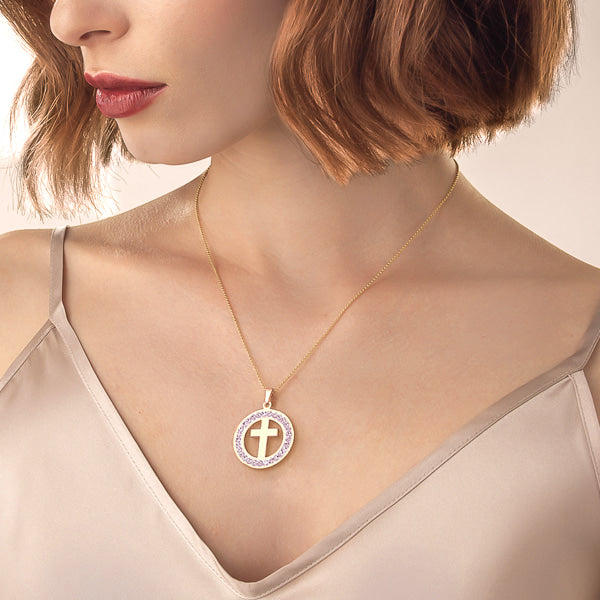 Woman wearing a gold crystal coin cross pendant necklace