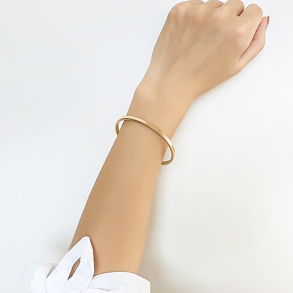 Gold cuff bracelet on a woman's wrist