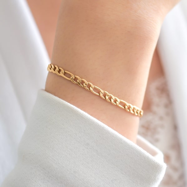 Gold figaro chain bracelet on a woman's wrist