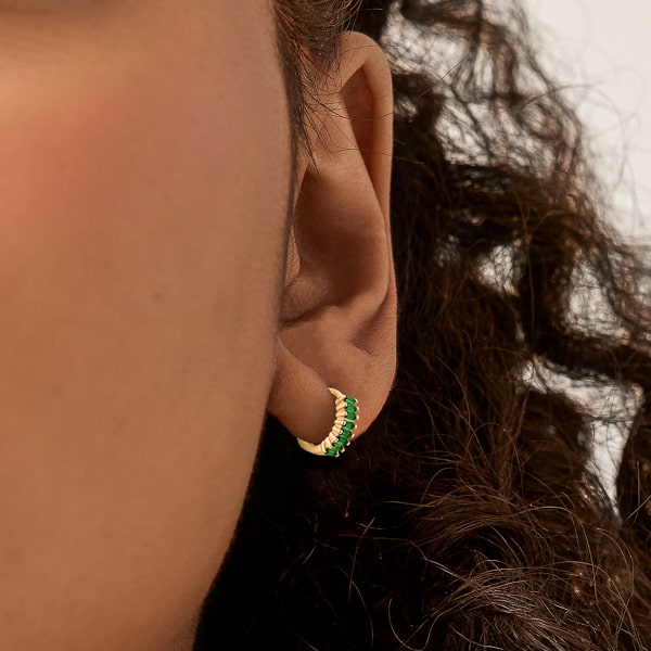 Gold green emerald-cut crystal huggie earrings on model