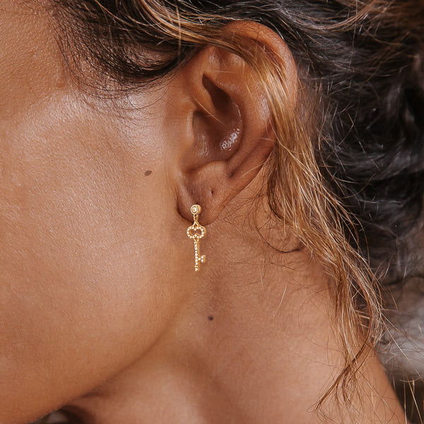 Woman wearing gold key earrings