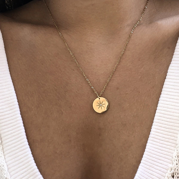 Gold north star necklace on woman's neck