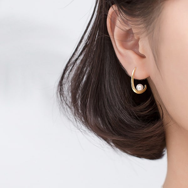 Model wearing gold open waterdrop hoop pearl earrings