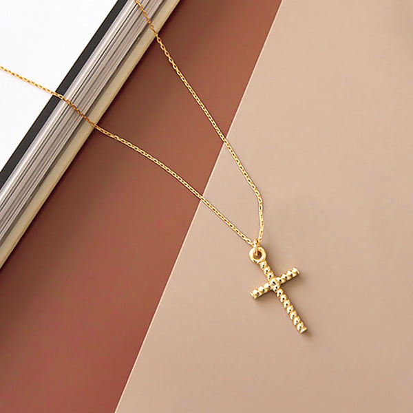 Twisted gold cross pendant necklace display