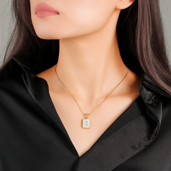 Woman wearing a Mother of Pearl initial card pendant necklace