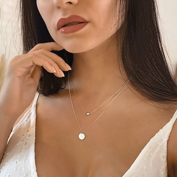 Woman wearing a two-layer sterling silver coin necklace