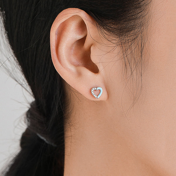 Woman wearing light blue heart stud earrings