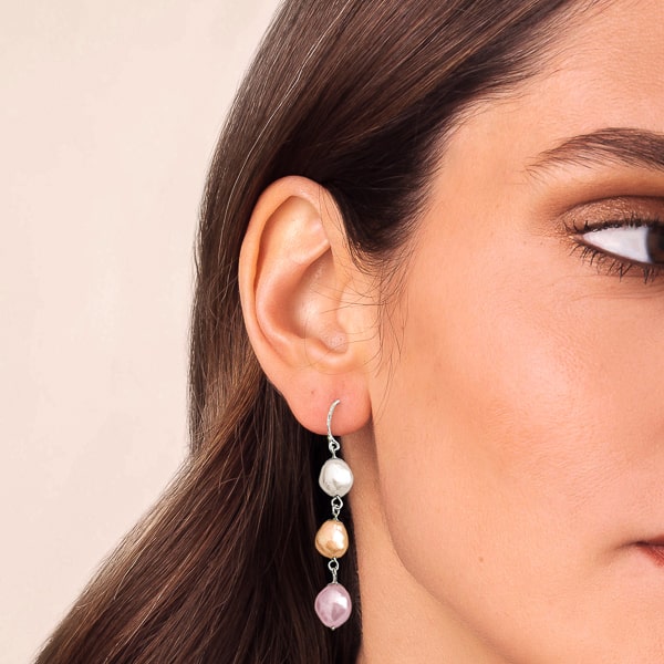 Woman wearing multicolor triple pearl drop earrings