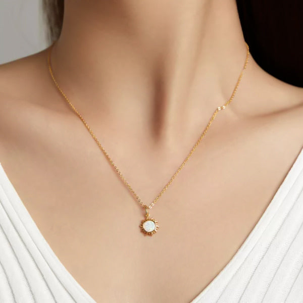 Woman wearing a gold opal sun pendant necklace