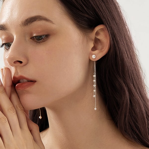 Woman wearing pearl dual drop chain earrings