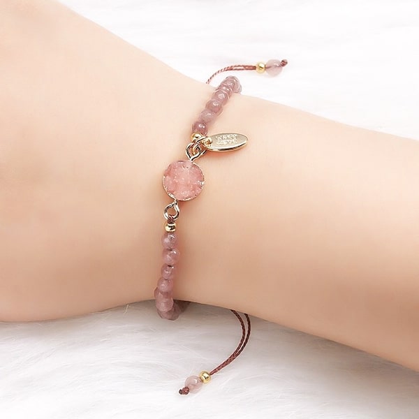 Woman wearing a pink beaded rose quartz geode bracelet
