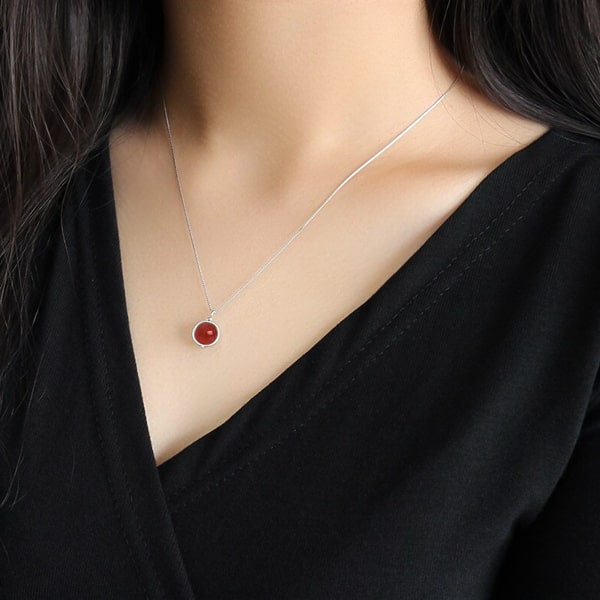 Woman wearing a red agate pendant necklace