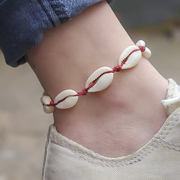 Red cowrie shell anklet on a womans ankle