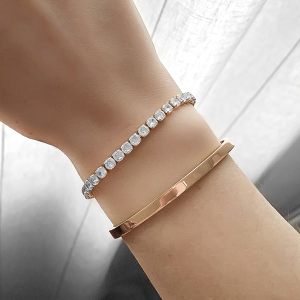 Woman wearing a 4mm rose gold bangle bracelet on her wrist