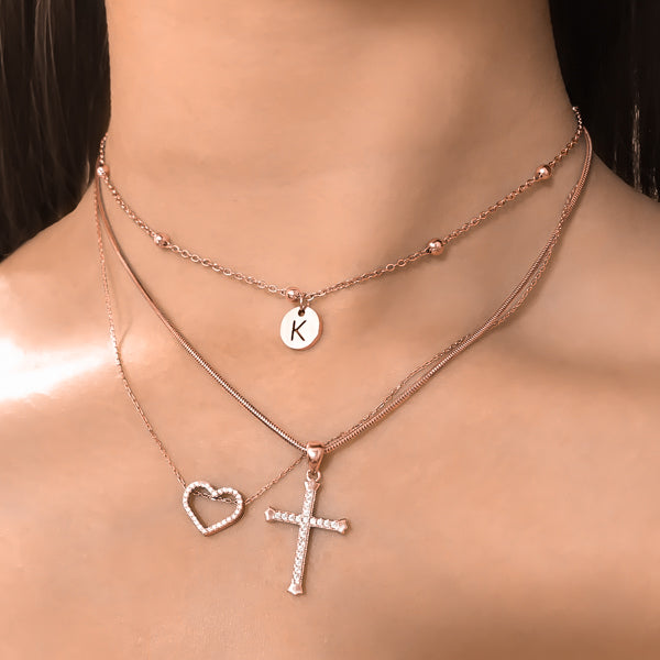 Woman wearing a beaded rose gold initial disc choker necklace