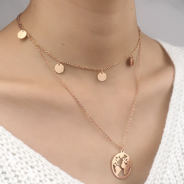 Woman wearing a rose gold layered world necklace with globe earth pendant