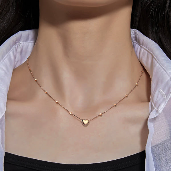Woman wearing a rose gold beaded heart chain necklace