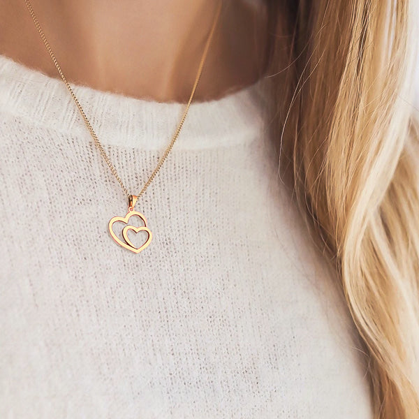 Woman wearing a rose gold double heart pendant necklace