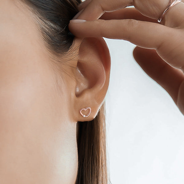 Rose gold open heart stud earrings on model