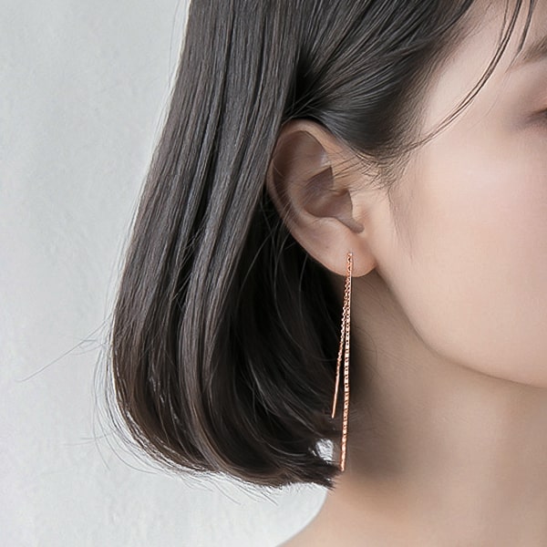 Woman wearing rose gold threader earrings