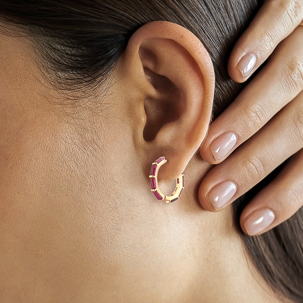 Woman wearing rose red baguette-cut crystal hoop earrings