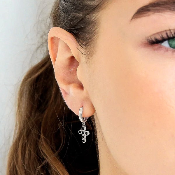 Woman wearing silver black crystal cross mini hoop earrings