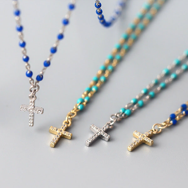 Silver necklace with blue beads and a crystal cross display