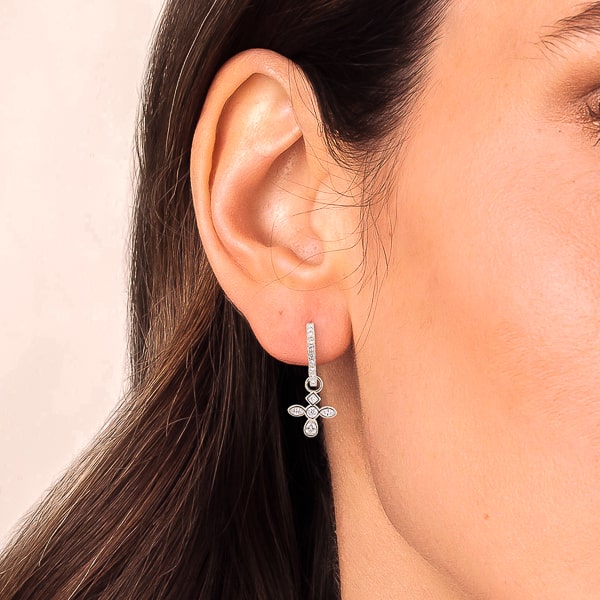 Woman wearing silver crystal cross c hoop earrings