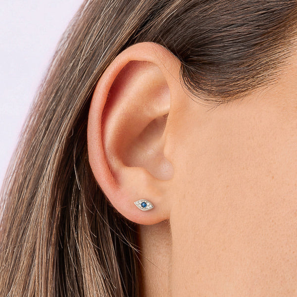 Woman wearing silver crystal eye stud earrings