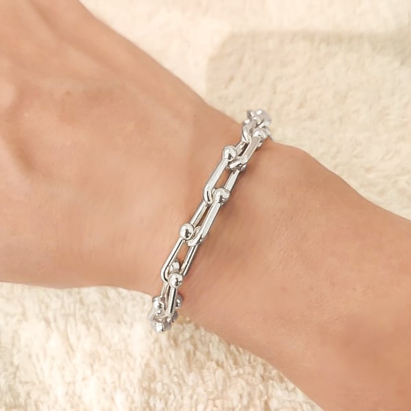 Silver designer link chain bracelet on a woman's wrist