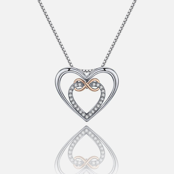 Details of the dual heart pendant with an infinity symbol hanging form a silver chain