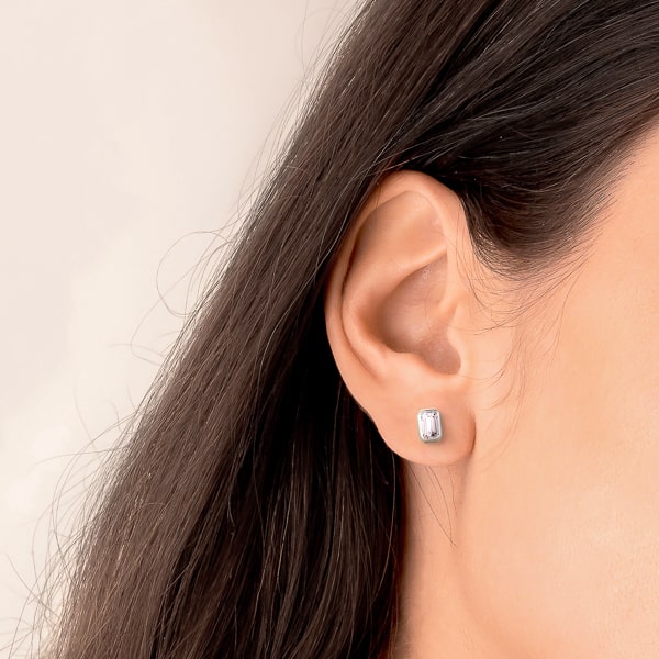 Woman wearing silver emerald-cut crystal stud earrings