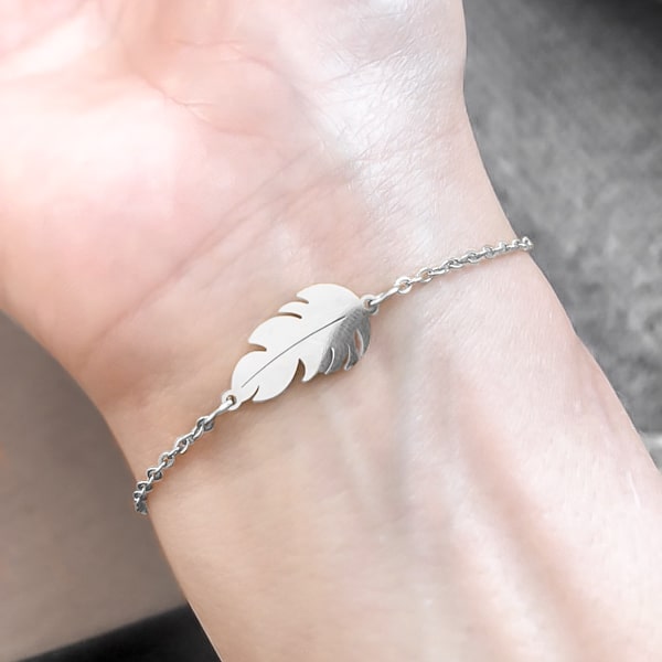 Silver feather bracelet on a woman's wrist