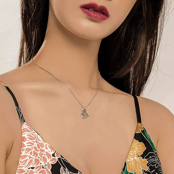 Woman wearing a silver geometric heart pendant necklace
