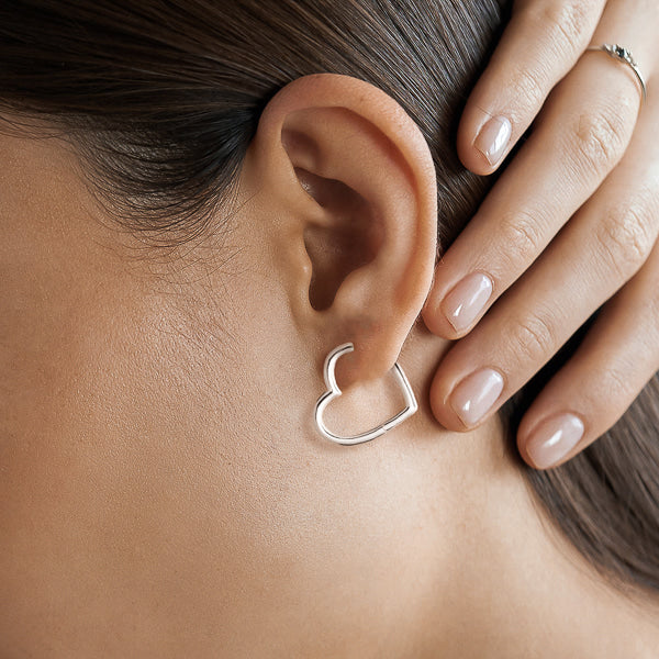Silver heart hoop earrings on model
