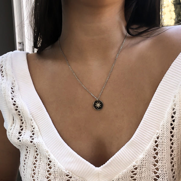 Silver north star necklace on woman's neck