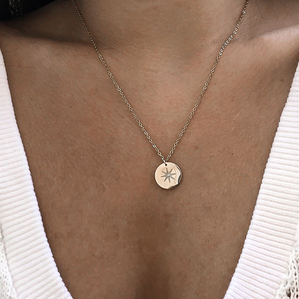 Woman wearing a silver north star necklace