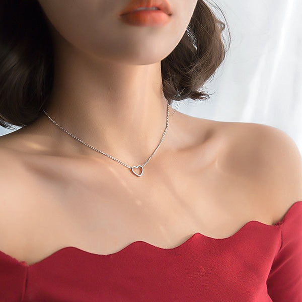 Woman wearing a silver open heart choker necklace